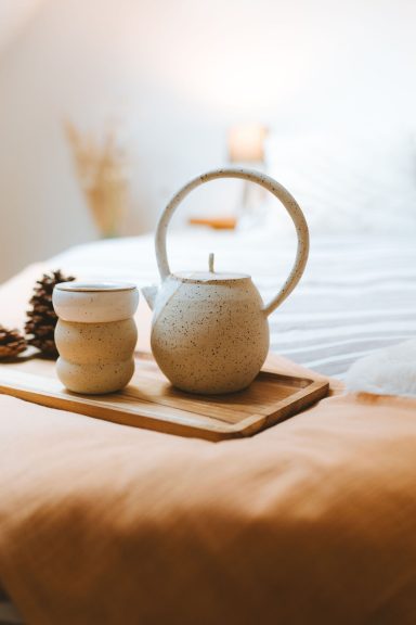 Théière et tasse sur un plateau, avec une ambiance chaleureuse dans une chambre.